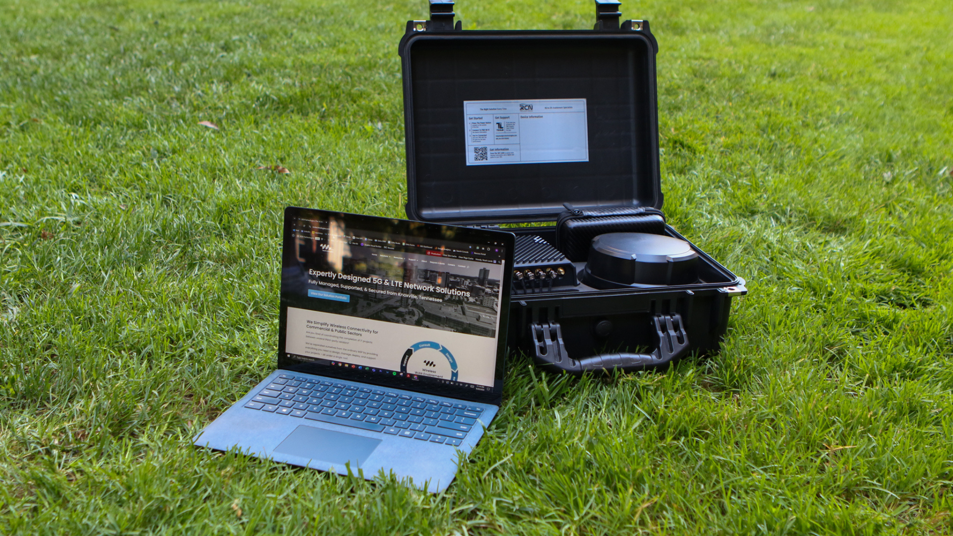 laptop and PNK sitting in grass