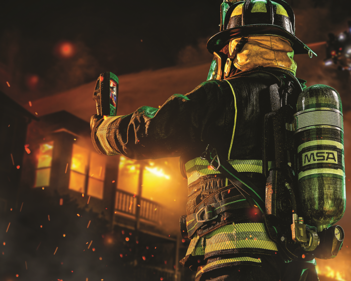 Fireman walking by firetruck with wildfire in background